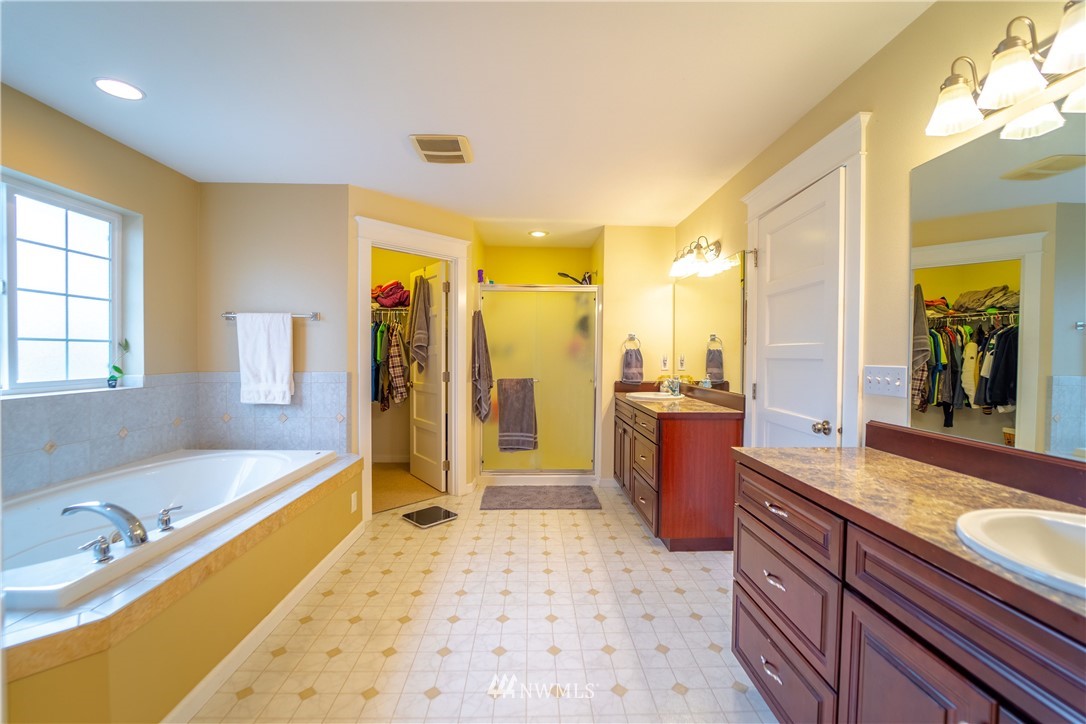 111 Garrett Loop Chehalis, WA 98532 - Photo 17 of 36 a large bathroom with a tub a sink and a large mirror