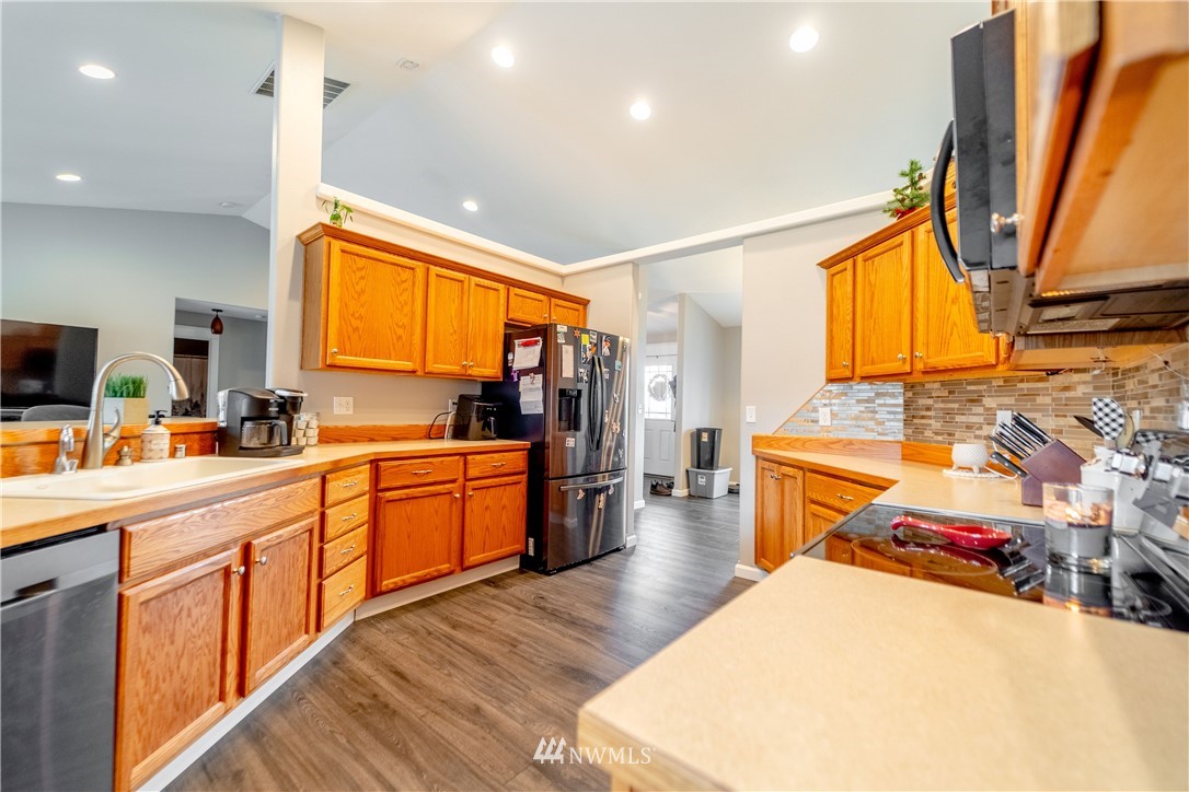 111 Garrett Loop Chehalis, WA 98532 - Photo 8 of 36 a kitchen with stainless steel appliances kitchen island granite countertop a sink a stove cabinets counter space and a window