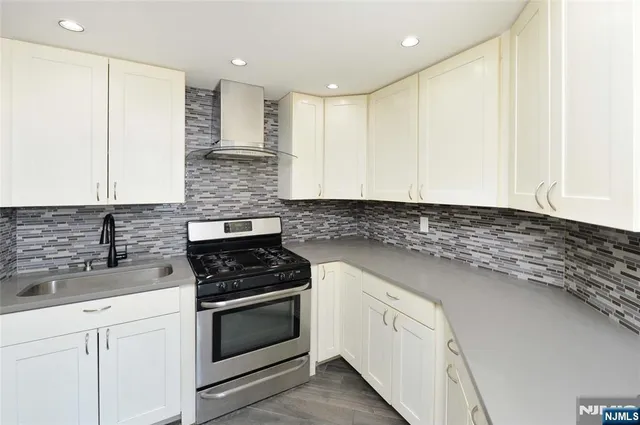a kitchen with granite countertop white cabinets and white appliances