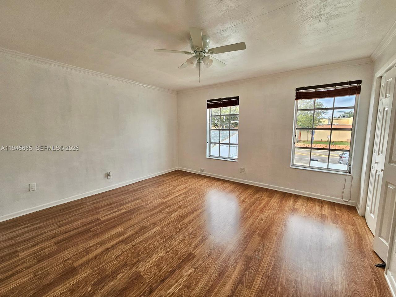 0 West Th Hialeah, FL 33014 - Photo 16 of 21 an empty room with wooden floor fan and windows