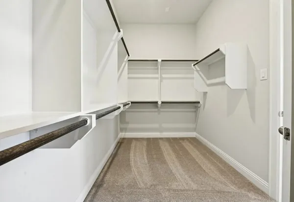 a view of walk in closet with empty racks