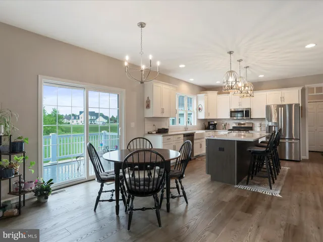 a view of a dining room and livingroom with furniture wooden floor a chandelier
