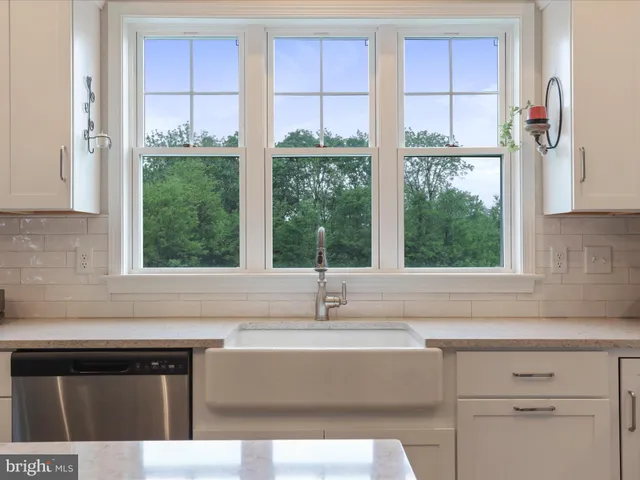 a sink with a window and cabinets