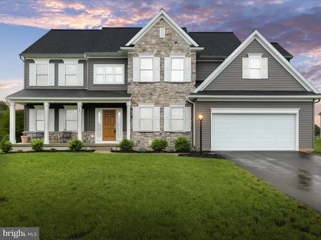 a front view of a house with a garden and yard