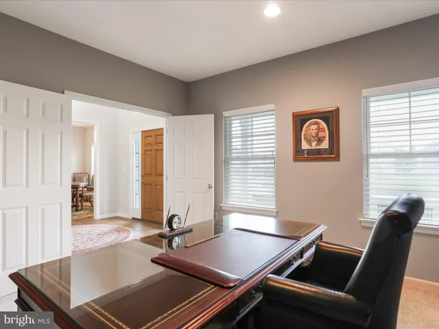 a view of a workspace with furniture and a window