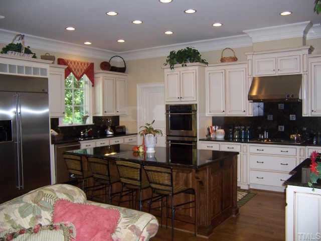 2722 Fairview Road Raleigh, NC 27608 - Photo 7 of 10 a kitchen with kitchen island granite countertop a sink a counter top space appliances and cabinets