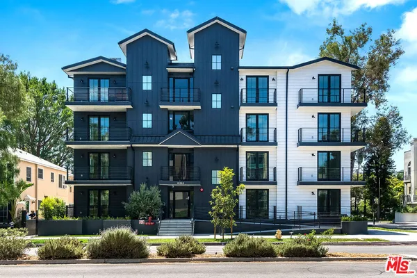 a front view of a residential apartment building with a yard