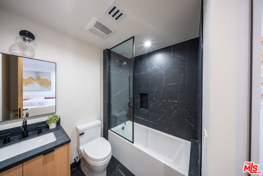 10352 Riverside Drive, Unit 103 Toluca Lake, CA 91602 - Photo 8 of 10 a bathroom with a bathtub shower sink vanity and toilet