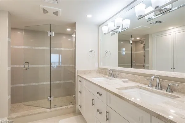 a bathroom with a granite countertop sink mirror and shower