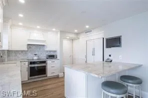 a kitchen with stainless steel appliances granite countertop a sink a stove and a refrigerator