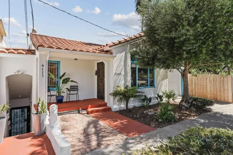 a view of a porch with chairs and potted plants