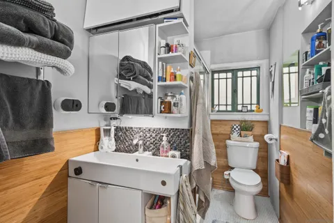 a bathroom with a toilet sink and mirror