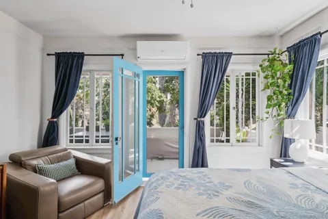 a bedroom with furniture and a large window