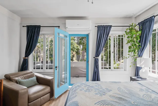 a bedroom with furniture and a large window