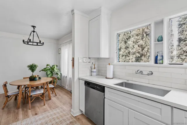 a kitchen with stainless steel appliances a sink a table and chairs in it