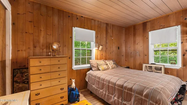 a bedroom with a bed and a dresser next to a window