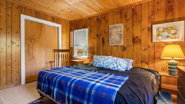 a bedroom with a bed and a painting on the wall