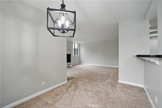 a view of a hallway with wooden floor and a chandelier