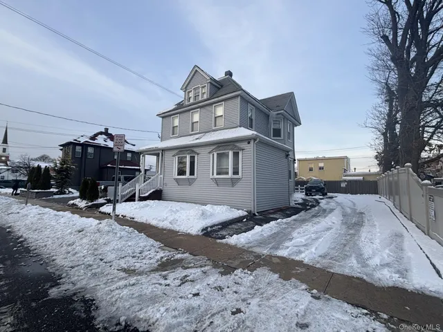 a view of a house with a yard covered in snow