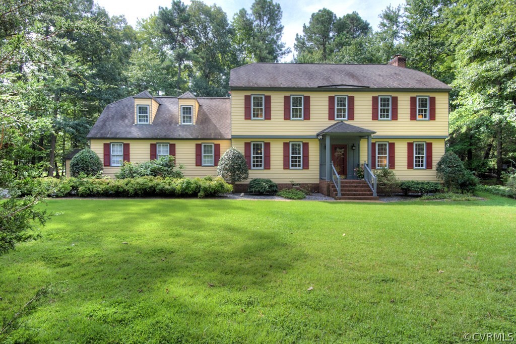 a front view of a house with a yard and trees