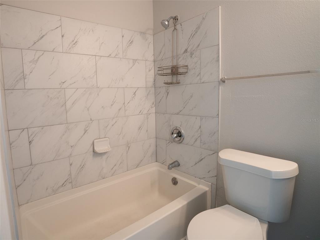 3651 North Goldenrod Road, Unit E205 Winter Park, FL 32792 - Photo 17 of 19 a white toilet sitting next to a bath tub and a shower