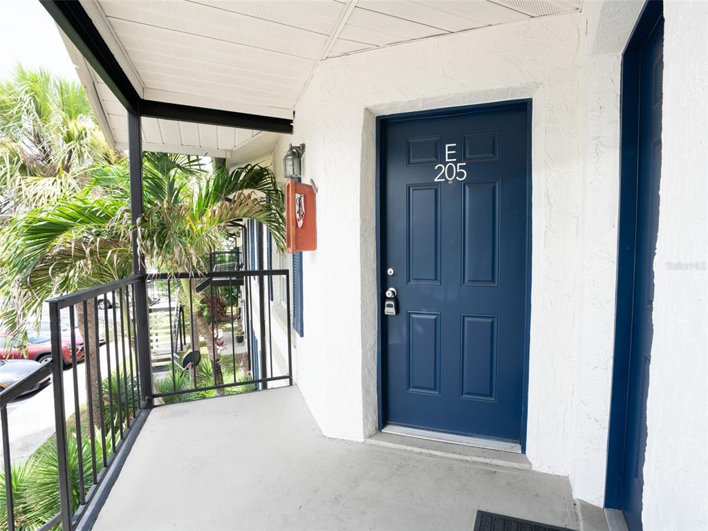 3651 North Goldenrod Road, Unit E205 Winter Park, FL 32792 - Photo 2 of 19 a view of a porch with a door and tree