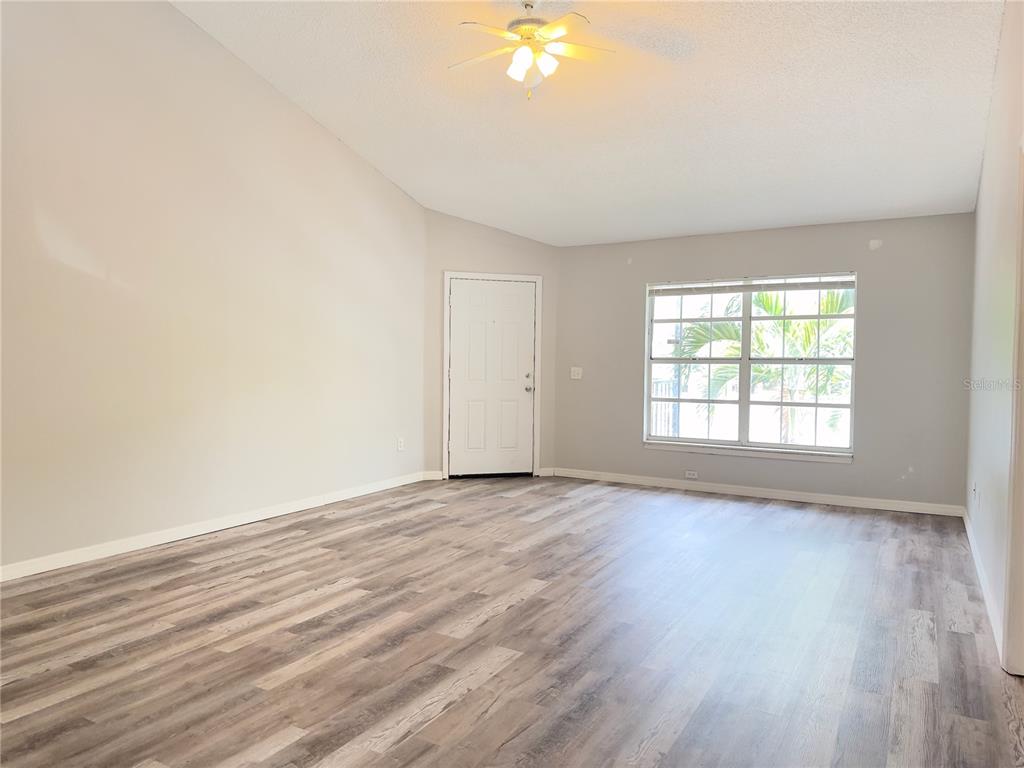 3651 North Goldenrod Road, Unit E205 Winter Park, FL 32792 - Photo 4 of 19 an empty room with wooden floor and windows