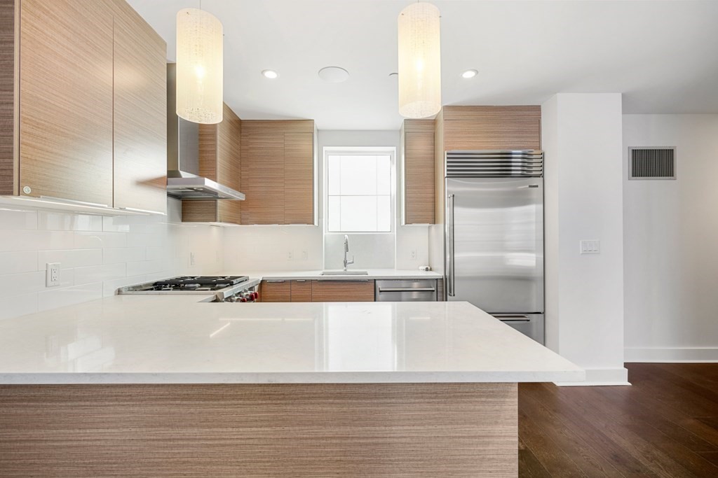 a large white kitchen with wooden floor