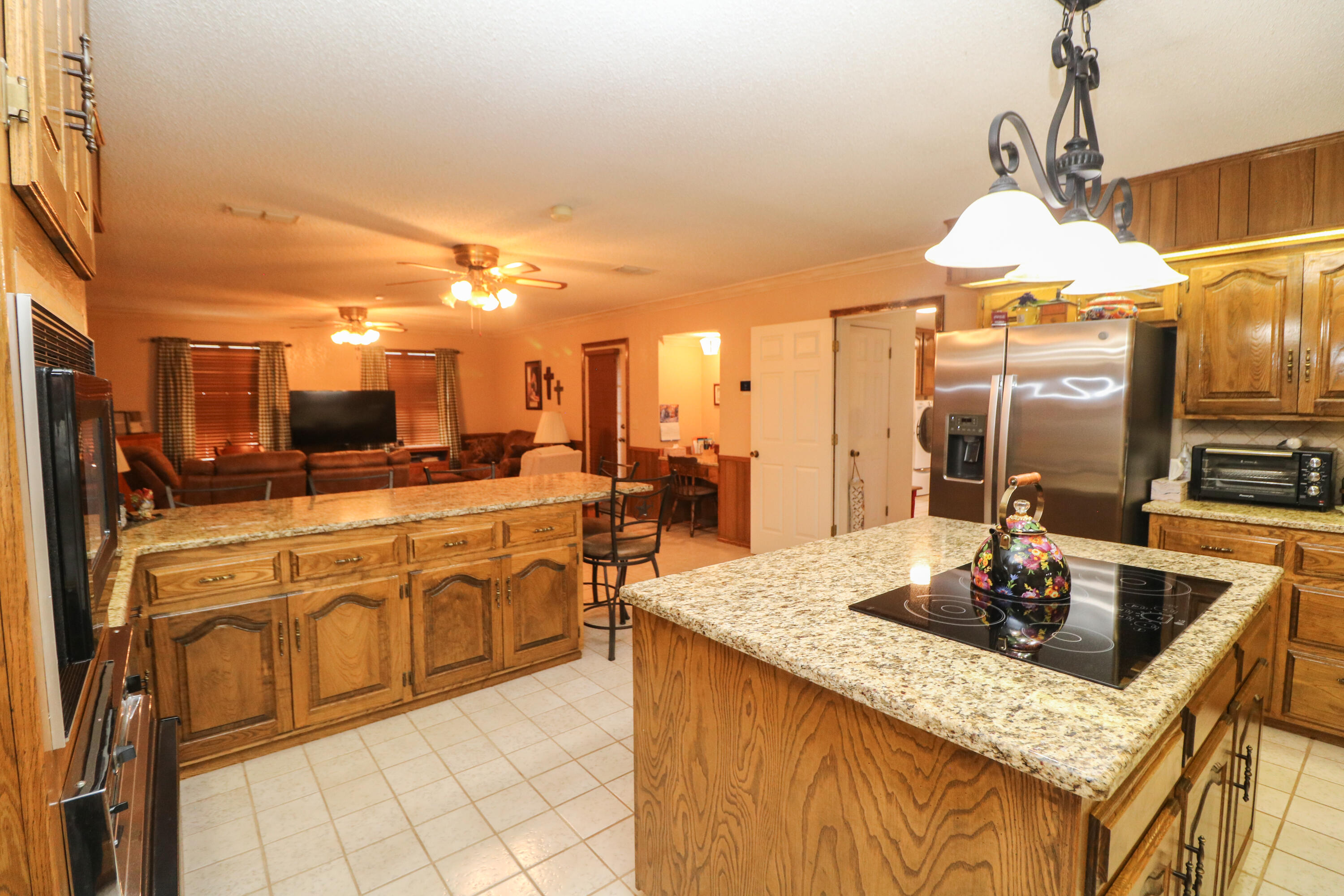 2801 Phelps Avenue Littlefield, TX 79339 - Photo 6 of 38 a kitchen with stainless steel appliances granite countertop a sink a stove and a wooden floors