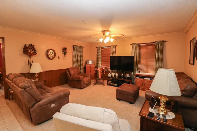 a living room with furniture kitchen view and a flat screen tv
