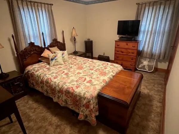 a bed sitting in a bedroom next to a window with tv