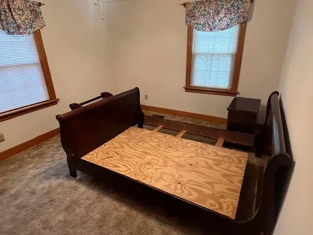 a bed sitting in a bedroom next to a window
