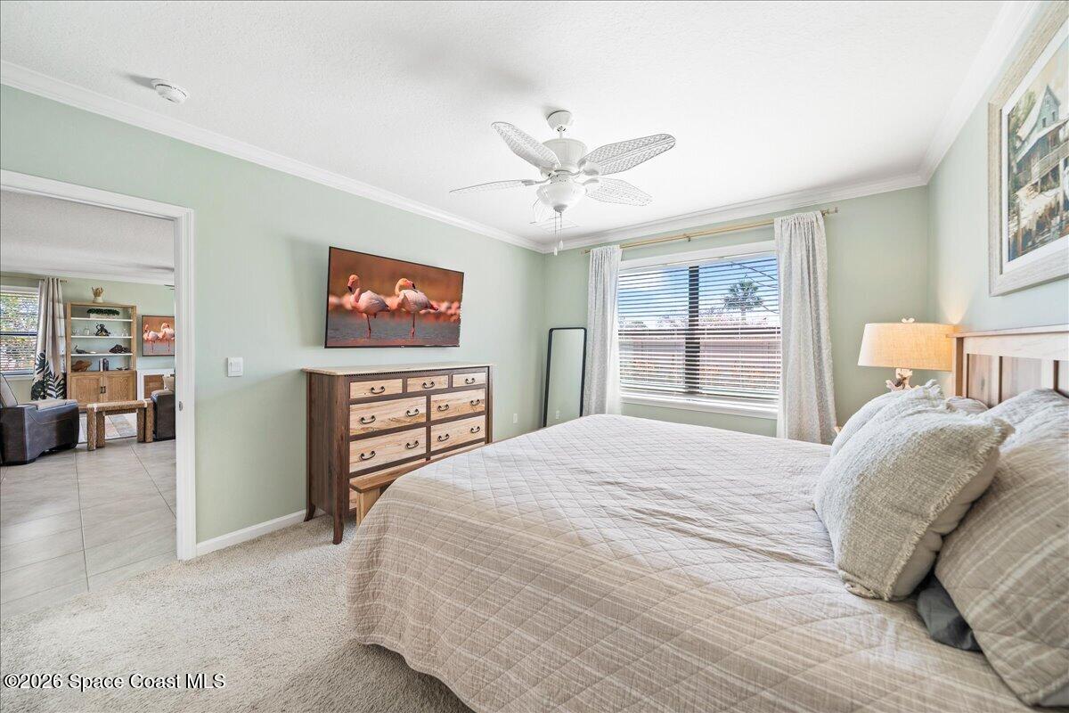 7499 Tourmaline Drive Grant, FL 32949 - Photo 16 of 41 a bedroom with a large bed and a chandelier