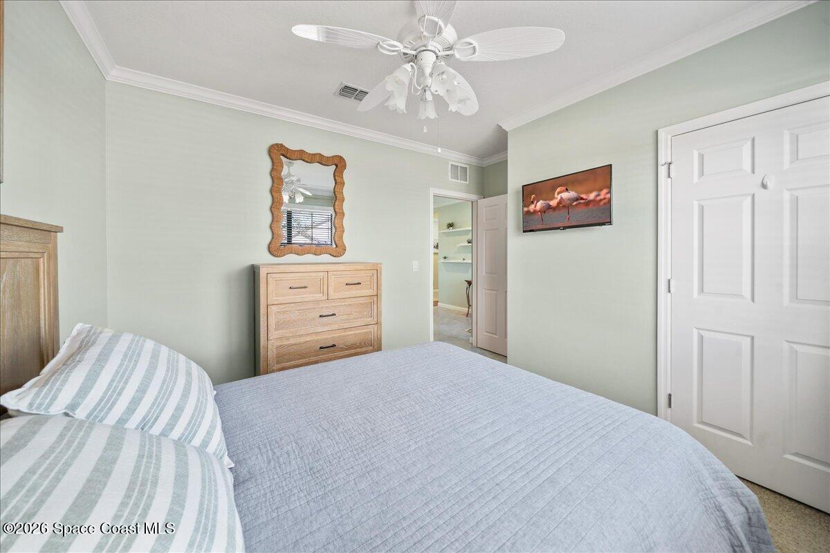 7499 Tourmaline Drive Grant, FL 32949 - Photo 22 of 41 a bedroom with a bed and a chandelier
