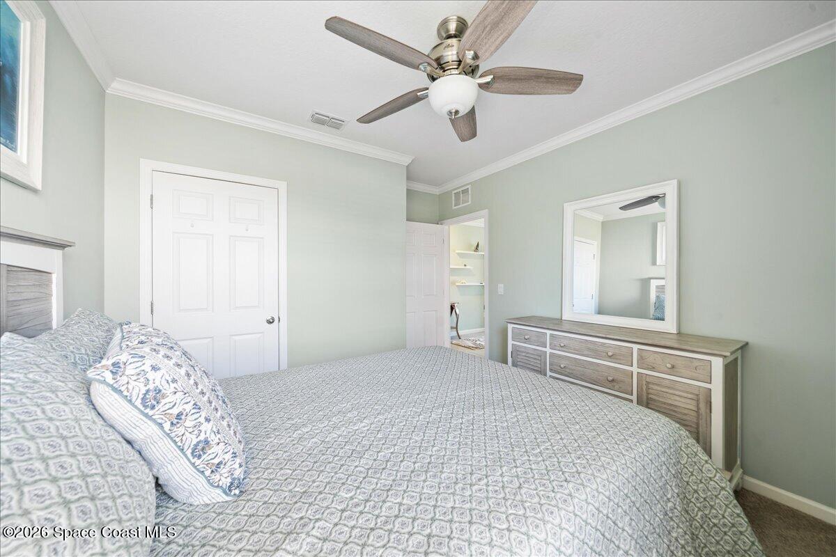 7499 Tourmaline Drive Grant, FL 32949 - Photo 26 of 41 a bedroom with a large bed and a chandelier fan