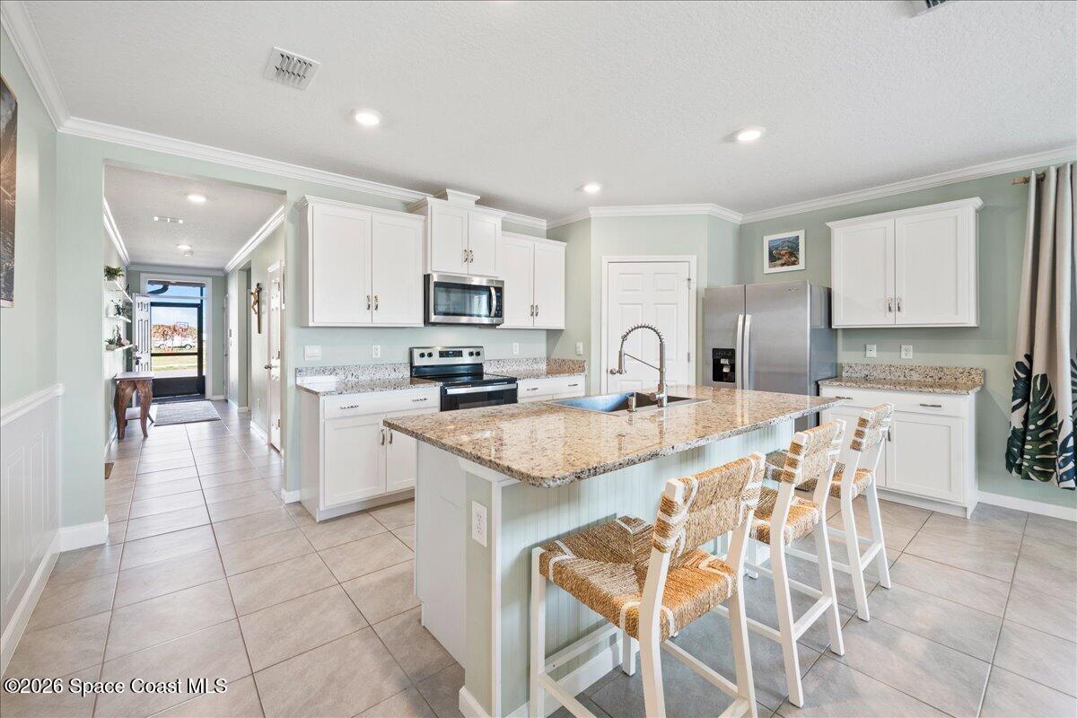 7499 Tourmaline Drive Grant, FL 32949 - Photo 4 of 41 a kitchen with kitchen island granite countertop a counter top space appliances and cabinets