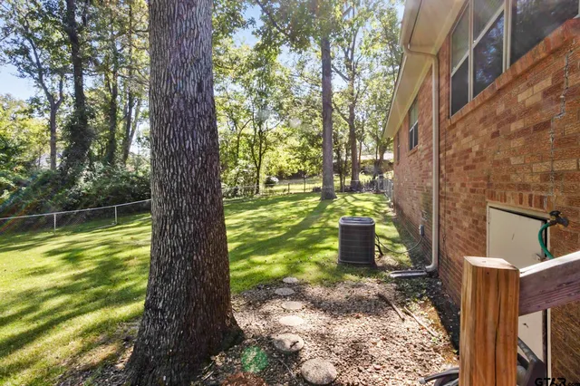 a view of a yard with plants and a bench