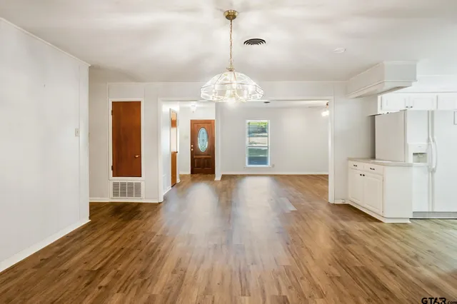 a view of a big room with wooden floor and a kitchen