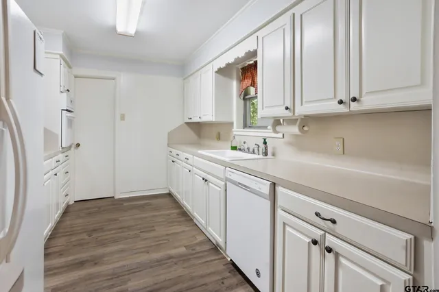 a kitchen with white cabinets and sink