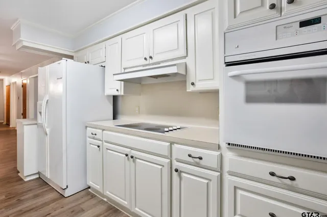a kitchen with white cabinets and white appliances