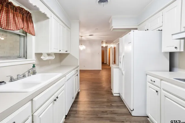 a kitchen with granite countertop a sink stove and refrigerator