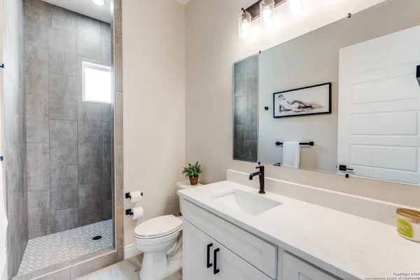 a bathroom with a sink a toilet and shower