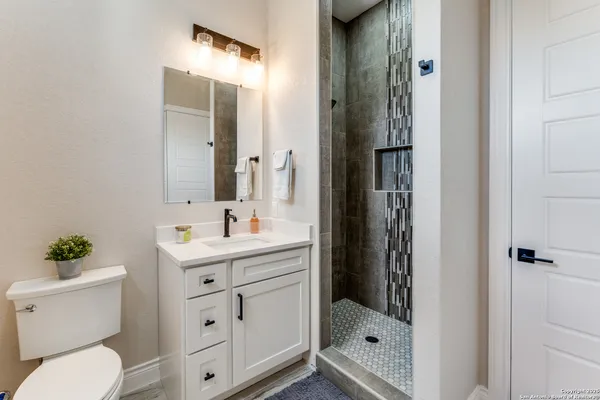 a bathroom with a sink a toilet and shower