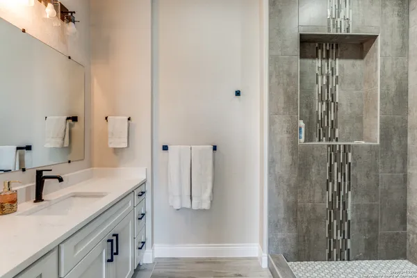 a bathroom with a granite countertop shower sink and vanity