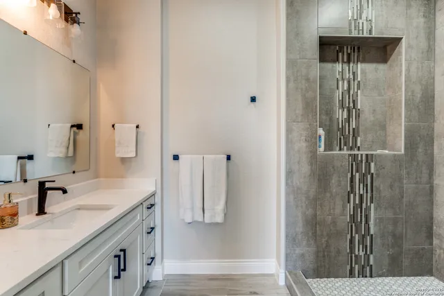 a bathroom with a granite countertop shower sink and vanity