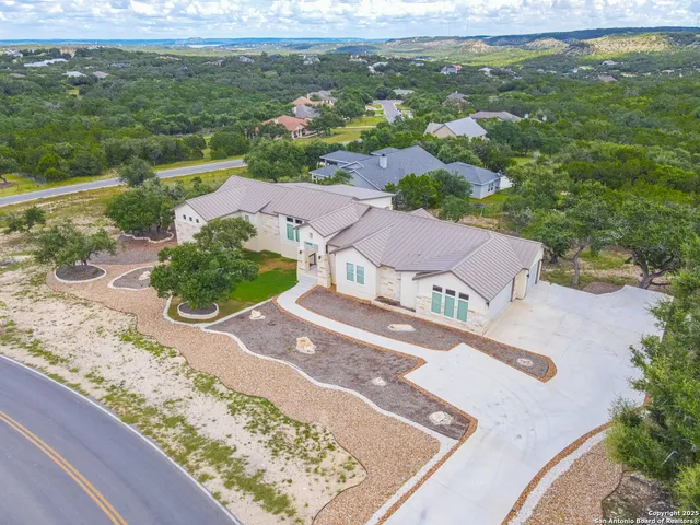 an aerial view of residential houses with outdoor space and trees