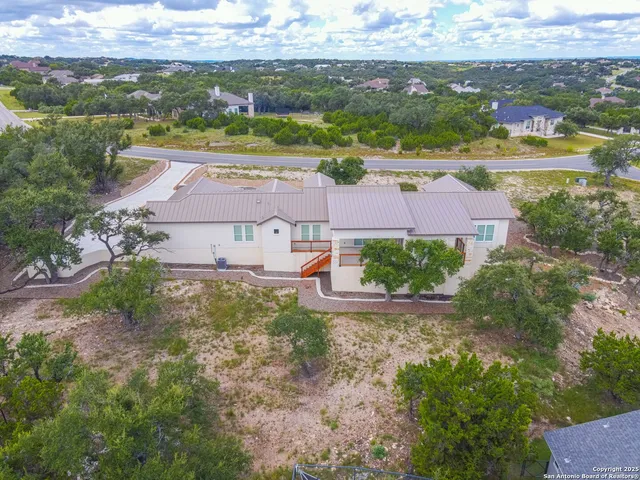 an aerial view of residential houses with outdoor space and ocean view