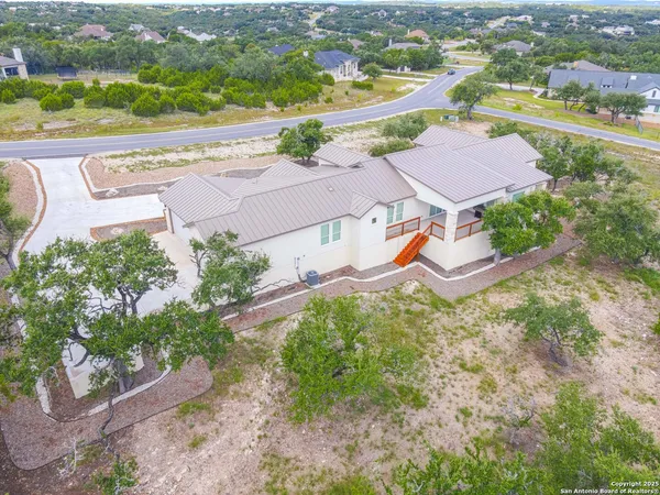 an aerial view of residential houses with outdoor space and parking