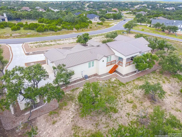an aerial view of residential houses with outdoor space and parking