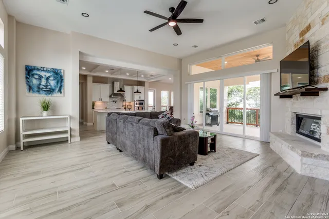 a living room with furniture a flat screen tv and a fireplace